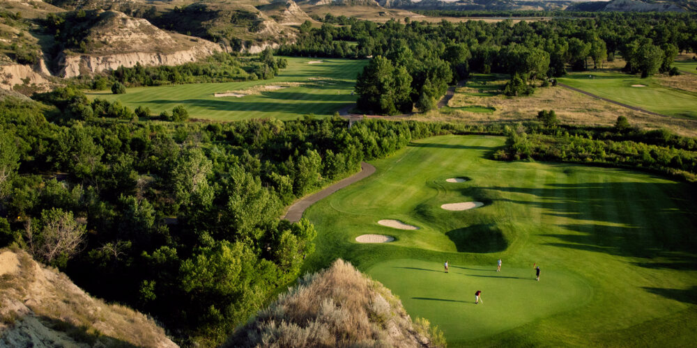 A foursome of golfers put at Bully Pulpit Golf Course in Medora, North Dakota, surrounded by the North Dakota Badlands