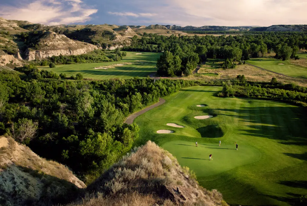 A foursome of golfers put at Bully Pulpit Golf Course in Medora, North Dakota, surrounded by the North Dakota Badlands