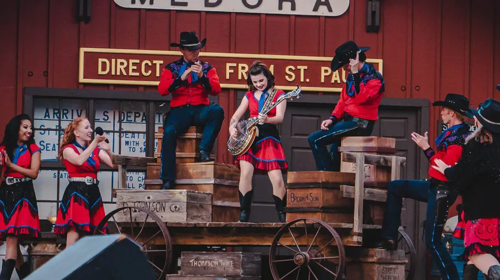 Burning Hills Singers dressed in red western costumes clap and cheer on the Banjo player in the Medora Musical in Medora, North Dakota.
