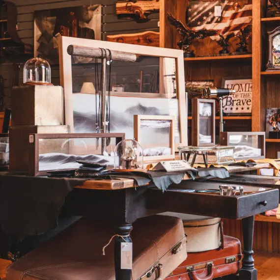 A desk is eclectically staged with art, jewelry and trinkets for sale at Rough Rider Gift in Medora, ND.