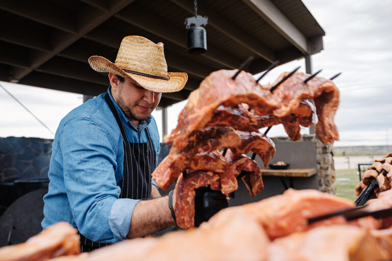A chef in a cowboy hat picks up a pitchfork loaded up with 12 oz steaks at the Pitchfork Steak Fondue, a dining attraction in Medora, North Dakota