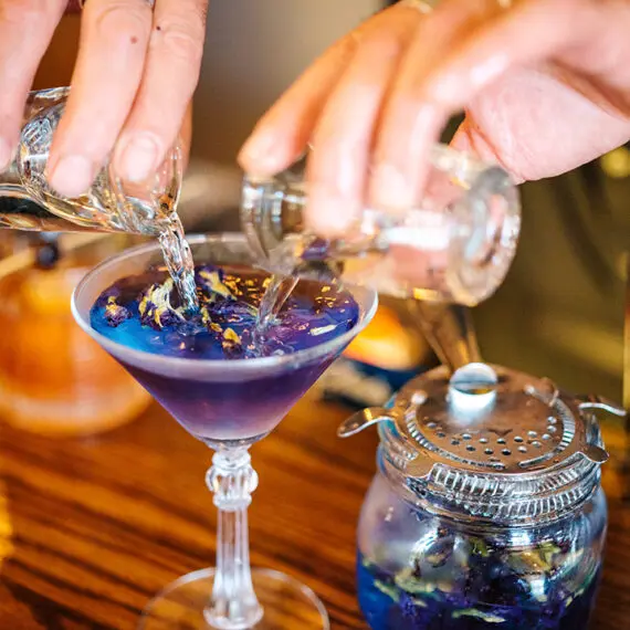 A man pours two shots into a cocktail in a bar in Medora, North Dakota