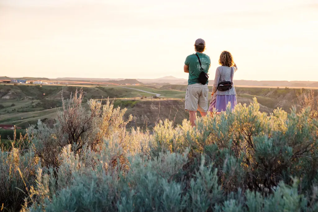 Overlook a view of town, Badlands, and the sunset on Point to Point Trails, a hiking trail in Medora, North Dakota