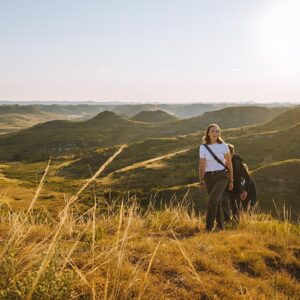 Hikers crest a sunny hill in the North Dakota Badlands, Theodore Roosevelt National Park, Medora, ND